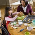 girl in wheelchair baking with mother